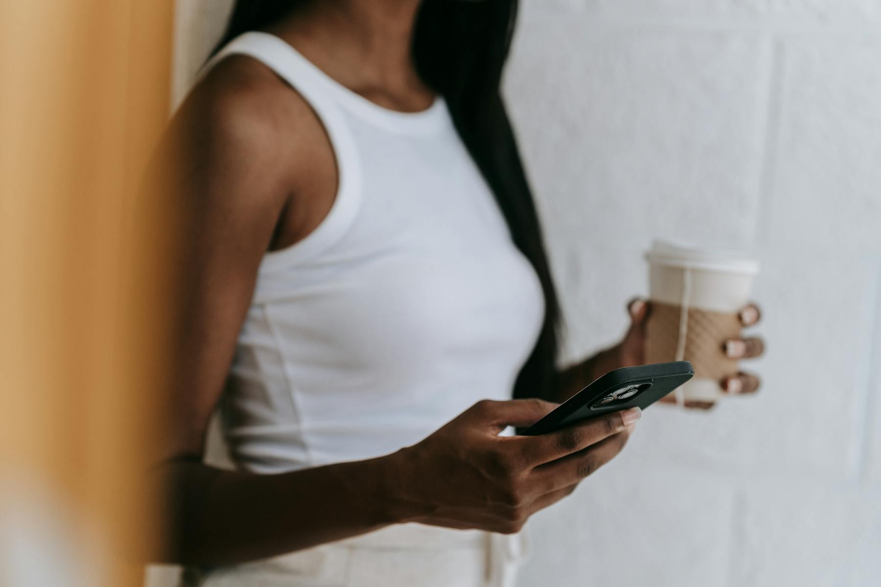 Person holding their phone with a coffee
